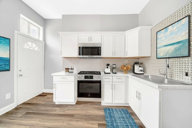 396 E Kensington Ave, Chicago, IL 60628 - kitchen featuring stainless steel microwave, electric range, backsplash, light countertops, and white cabinets
