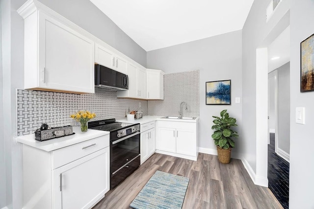 396 E Kensington Ave, Chicago, IL 60628 - kitchen with black appliances, tasteful backsplash, light wood-style floors, and white cabinetry