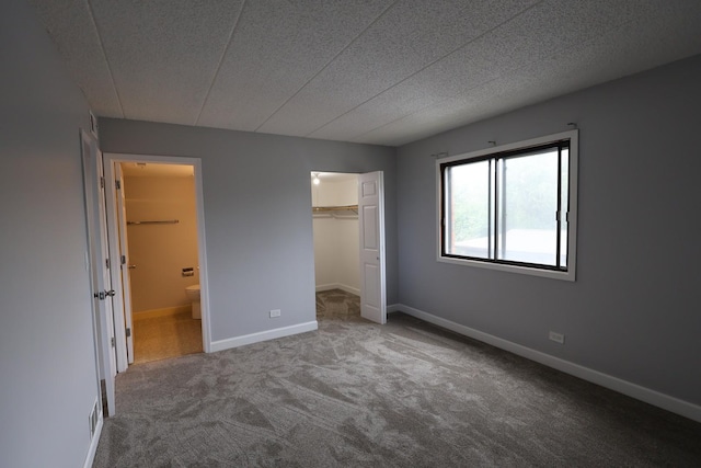 15103 Quail Hollow Dr Unit 604, Orland Park, IL 60462 - unfurnished bedroom featuring carpet floors, connected bathroom, a textured ceiling, and a walk in closet