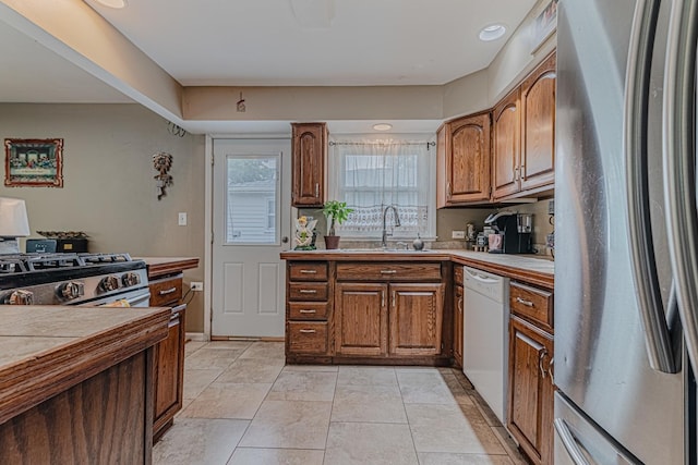 374 Heine Ave, Elgin, IL 60123 - kitchen featuring stainless steel appliances, brown cabinetry, tile countertops, and light tile patterned flooring