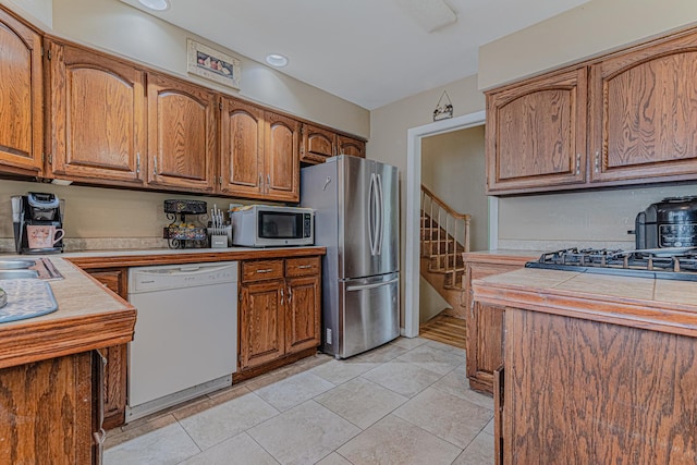 374 Heine Ave, Elgin, IL 60123 - kitchen featuring appliances with stainless steel finishes, brown cabinetry, and tile countertops