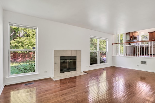 1379 Clavey Ln, Gurnee, IL 60031 - unfurnished living room featuring wood finished floors, plenty of natural light, and a tiled fireplace