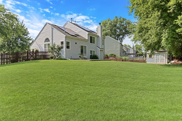 1379 Clavey Ln, Gurnee, IL 60031 - rear view of property featuring a chimney, a shed, and roof mounted solar panels