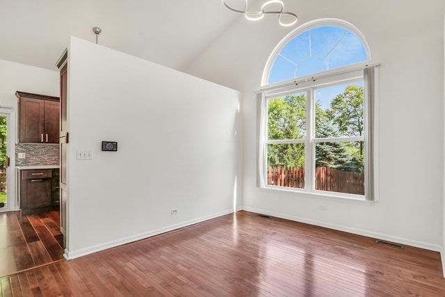 1379 Clavey Ln, Gurnee, IL 60031 - spare room with dark wood-type flooring, a towering ceiling, and a chandelier