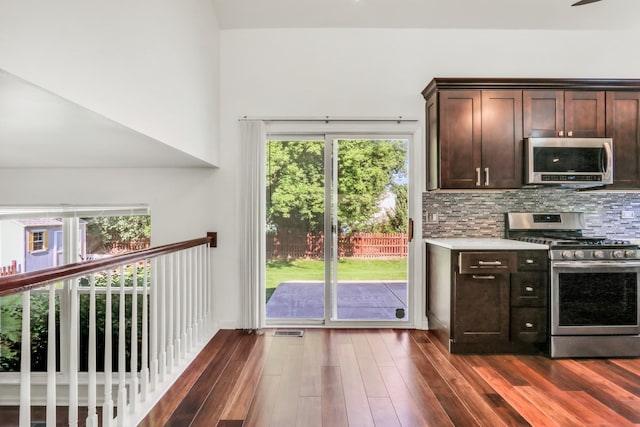 1379 Clavey Ln, Gurnee, IL 60031 - kitchen featuring appliances with stainless steel finishes, dark brown cabinetry, dark wood finished floors, decorative backsplash, and light countertops