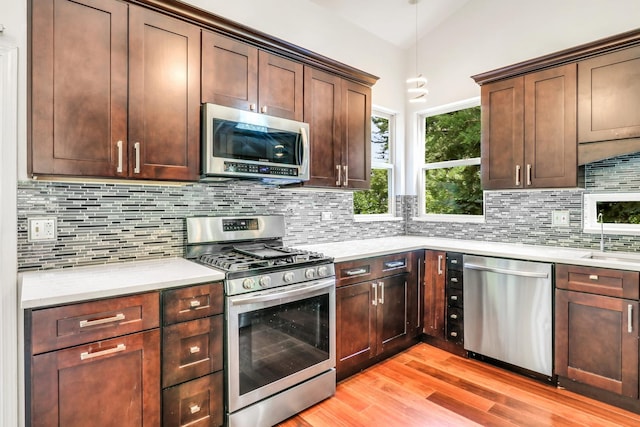 1379 Clavey Ln, Gurnee, IL 60031 - kitchen featuring stainless steel appliances, light wood-style flooring, light countertops, backsplash, and dark brown cabinetry
