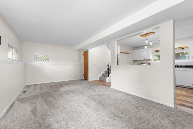 4809 Cayuga Rd, Rockford, IL 61107 - unfurnished living room featuring light colored carpet and stairway