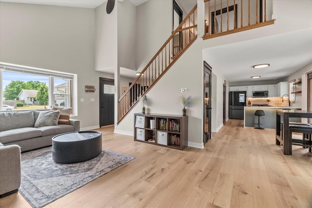 1617 Addleman St, Joliet, IL 60431 - living room featuring a high ceiling, stairway, and light wood finished floors
