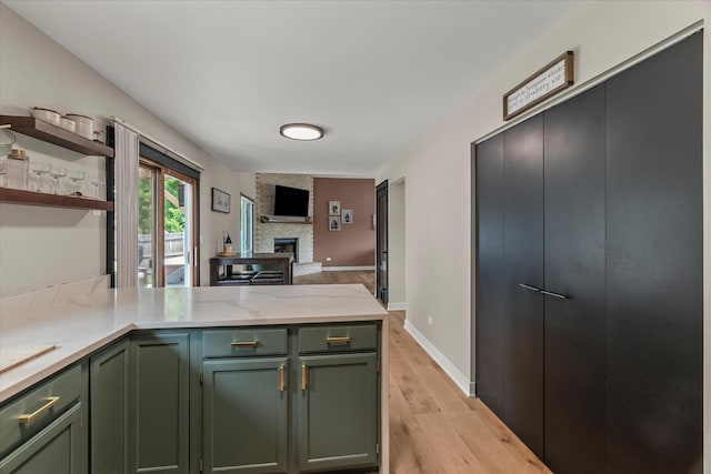 1617 Addleman St, Joliet, IL 60431 - kitchen with green cabinetry, a peninsula, open shelves, a brick fireplace, and light wood-type flooring