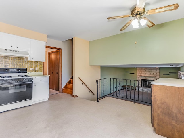 8564 Cherry Stone Pl, Tinley Park, IL 60487 - kitchen with white gas stove, under cabinet range hood, ceiling fan, white cabinets, and backsplash