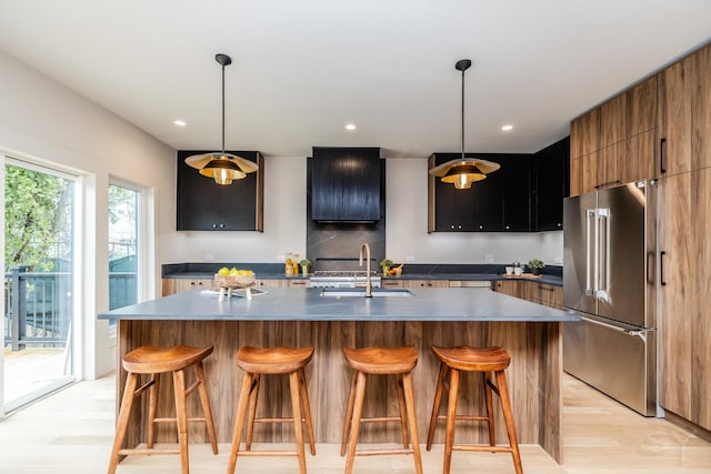 2715 Reese Ave, Evanston, IL 60201 - kitchen with high end refrigerator, light wood finished floors, a breakfast bar, a center island with sink, and modern cabinets