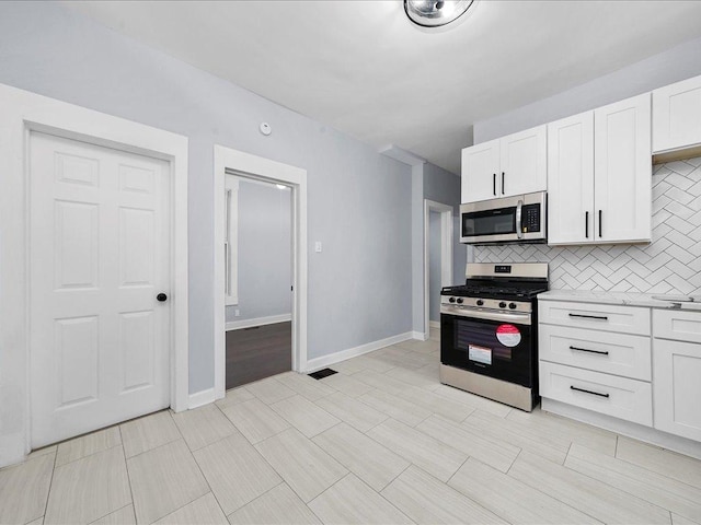 6501 S Hamilton Ave, Chicago, IL 60636 - kitchen with appliances with stainless steel finishes, decorative backsplash, light countertops, and white cabinets