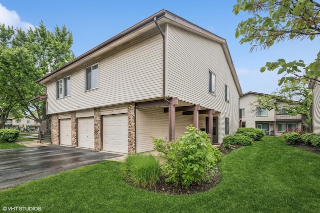 1340 Kingsbury Dr Unit 2, Hanover Park, IL 60133 - view of home's exterior featuring a garage, a lawn, driveway, and brick siding