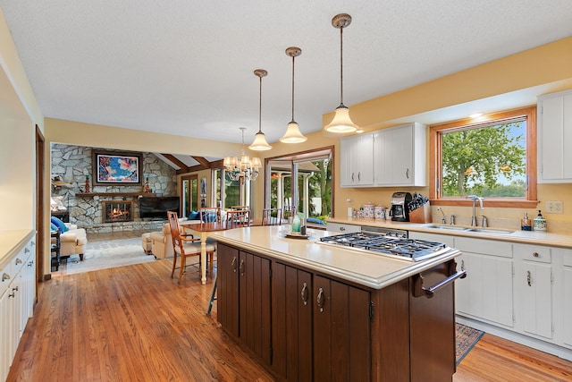 1606 Gregden Shores Dr, Sterling, IL 61081 - kitchen with stainless steel gas stovetop, a kitchen island, light countertops, light wood-type flooring, and open floor plan