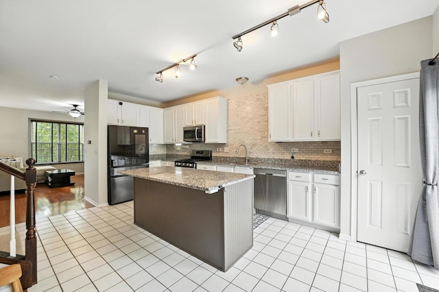 186 Willow Blvd, Willow Springs, IL 60480 - kitchen featuring stainless steel appliances, a kitchen island, light tile patterned floors, and white cabinetry