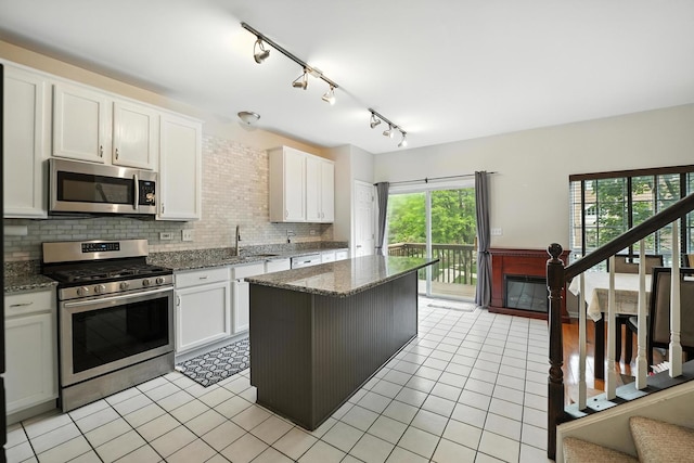 186 Willow Blvd, Willow Springs, IL 60480 - kitchen with stainless steel appliances, white cabinetry, light tile patterned floors, and decorative backsplash