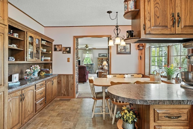 28457 S Yates Ave, Beecher, IL 60401 - kitchen featuring open shelves, ceiling fan, a wainscoted wall, brown cabinetry, and dark countertops