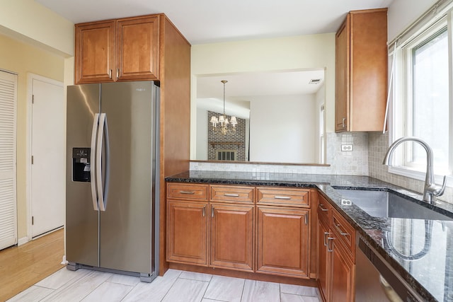 1918 N Yale Ave, Arlington Heights, IL 60004 - kitchen featuring appliances with stainless steel finishes, brown cabinets, dark stone counters, tasteful backsplash, and a chandelier