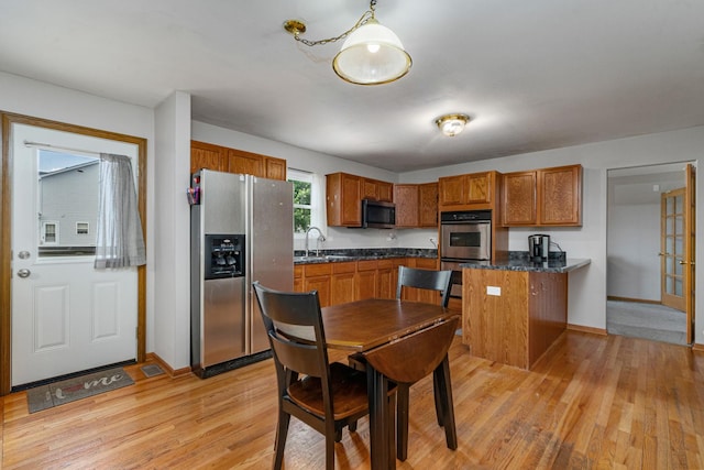 5505 Salma St, Plainfield, IL 60586 - kitchen featuring stainless steel appliances, dark countertops, brown cabinetry, and light wood finished floors