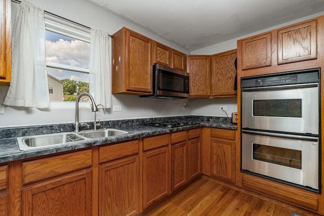 5505 Salma St, Plainfield, IL 60586 - kitchen with stainless steel appliances, wood finished floors, dark countertops, and brown cabinetry