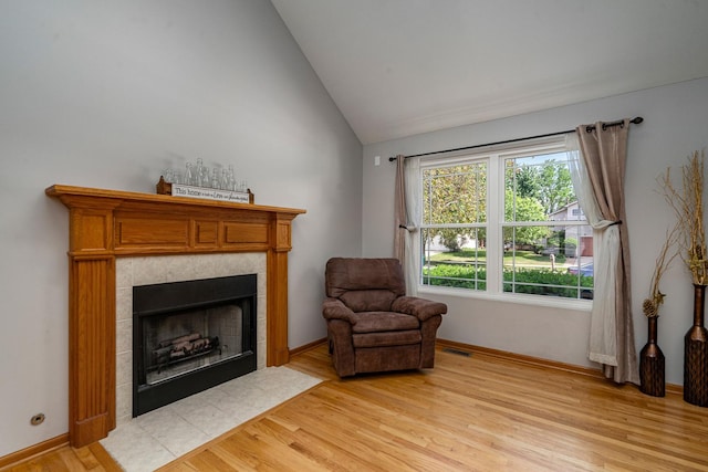 5505 Salma St, Plainfield, IL 60586 - living area with a tiled fireplace, light wood-style flooring, and vaulted ceiling
