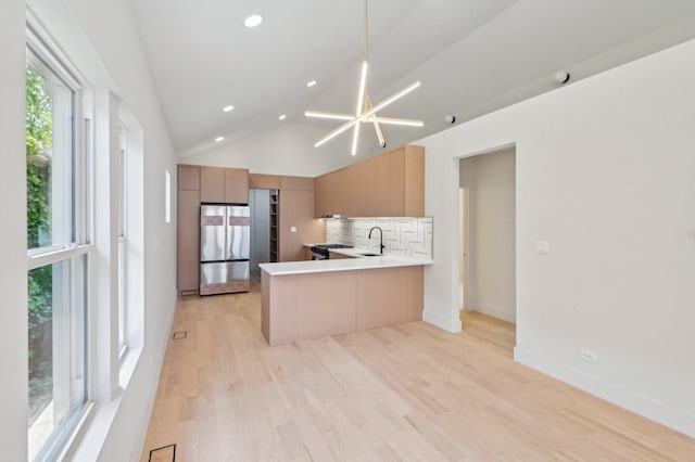 7930 S Kenwood Ave, Chicago, IL 60619 - kitchen featuring freestanding refrigerator, tasteful backsplash, a peninsula, light wood finished floors, and light countertops