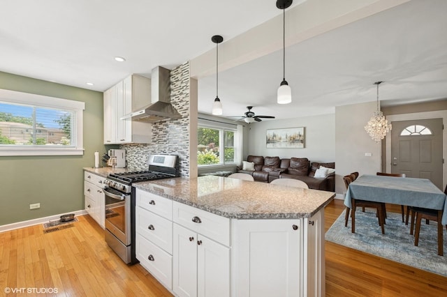 1308 Hoffman Ave, Park Ridge, IL 60068 - kitchen featuring stainless steel gas stove, wall chimney exhaust hood, light wood-style flooring, light stone countertops, and white cabinetry