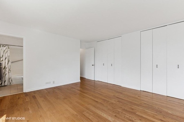 1450 N Astor St Unit 14D, Chicago, IL 60610 - unfurnished bedroom with multiple closets, wood finished floors, and connected bathroom