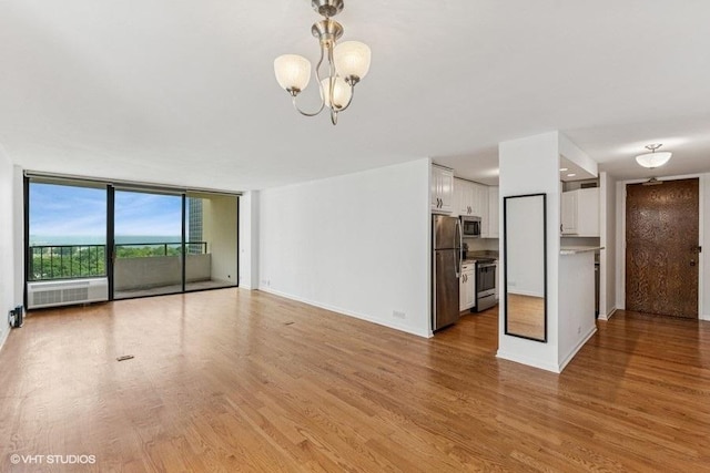 1450 N Astor St Unit 14D, Chicago, IL 60610 - unfurnished living room with a chandelier, light wood-style floors, floor to ceiling windows, and radiator