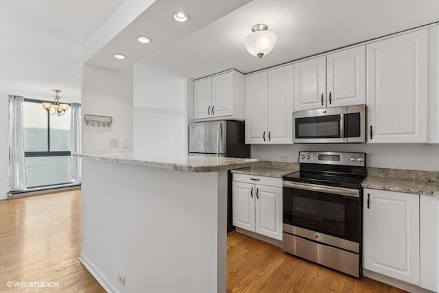 1450 N Astor St Unit 14D, Chicago, IL 60610 - kitchen with stainless steel appliances, white cabinetry, light wood-style flooring, a chandelier, and recessed lighting