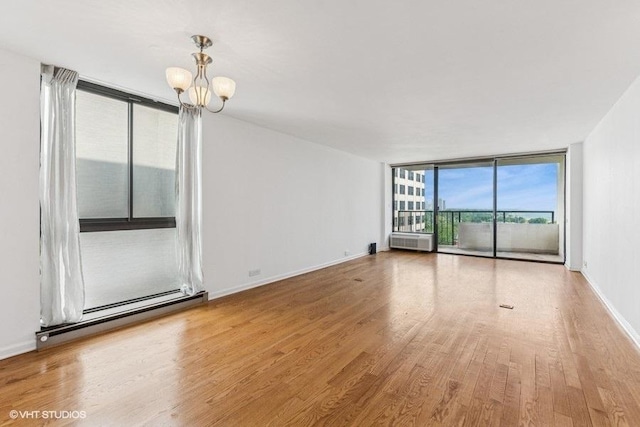 1450 N Astor St Unit 14D, Chicago, IL 60610 - empty room with a chandelier, expansive windows, wood finished floors, and a baseboard radiator
