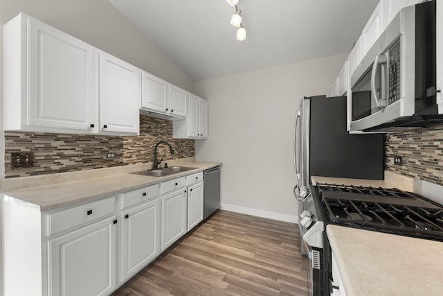 992 Langtry Ct Unit D, Elgin, IL 60120 - kitchen with stainless steel appliances, vaulted ceiling, backsplash, white cabinets, and light countertops