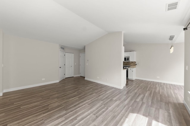 992 Langtry Ct Unit D, Elgin, IL 60120 - unfurnished living room featuring light wood-type flooring and vaulted ceiling