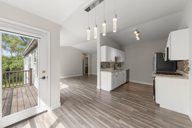 992 Langtry Ct Unit D, Elgin, IL 60120 - kitchen with lofted ceiling, decorative backsplash, appliances with stainless steel finishes, white cabinetry, and wood finished floors