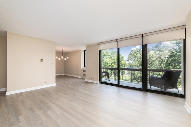 1110 Grove St Unit 4A, Downers Grove, IL 60515 - unfurnished room featuring a chandelier, light wood-style flooring, and expansive windows