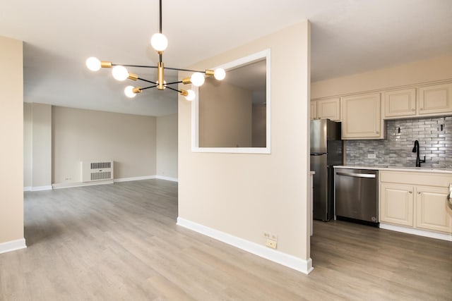 1110 Grove St Unit 4A, Downers Grove, IL 60515 - kitchen featuring appliances with stainless steel finishes, light wood-style floors, light countertops, a chandelier, and backsplash