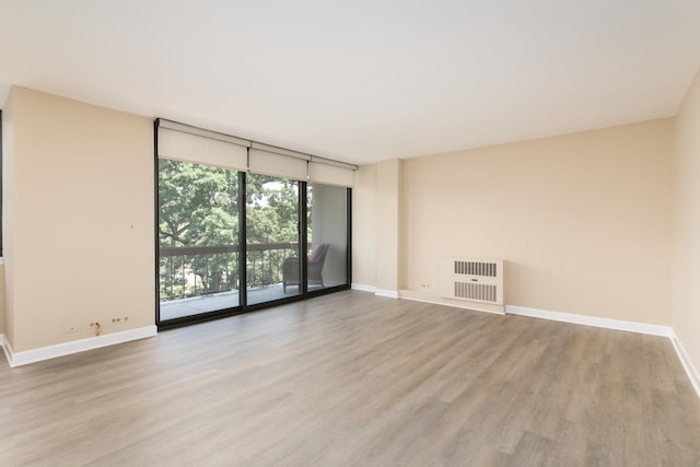 1110 Grove St Unit 4A, Downers Grove, IL 60515 - spare room with a wall of windows, light wood finished floors, and heating unit