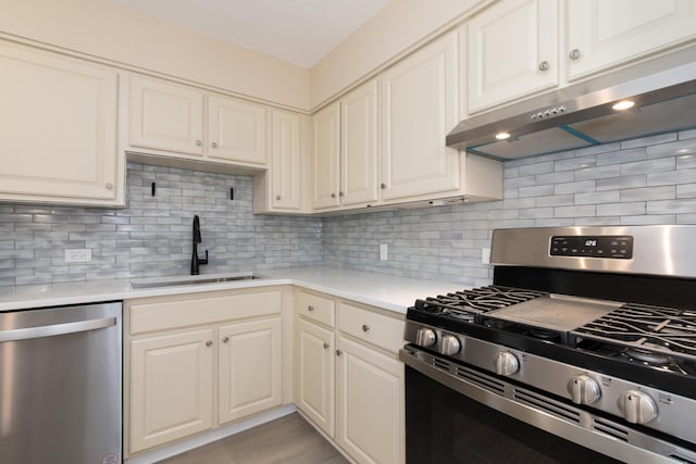 1110 Grove St Unit 4A, Downers Grove, IL 60515 - kitchen featuring appliances with stainless steel finishes, under cabinet range hood, light countertops, and tasteful backsplash