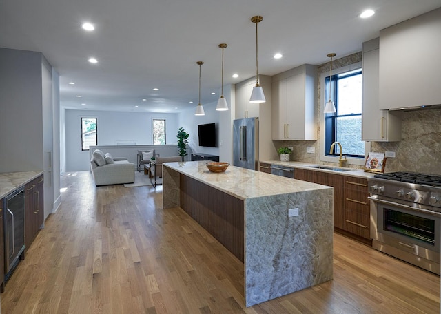 1332 N Leavitt St, Chicago, IL 60622 - kitchen with premium appliances, a kitchen island, light wood-type flooring, decorative backsplash, and recessed lighting