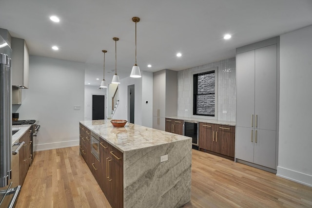 1332 N Leavitt St, Chicago, IL 60622 - kitchen with beverage cooler, stainless steel appliances, a kitchen island, light wood-style floors, and hanging light fixtures