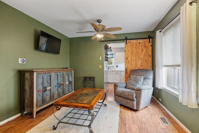 2706 Steamboat Cir, Plainfield, IL 60586 - living area featuring wood finished floors, a barn door, and a ceiling fan