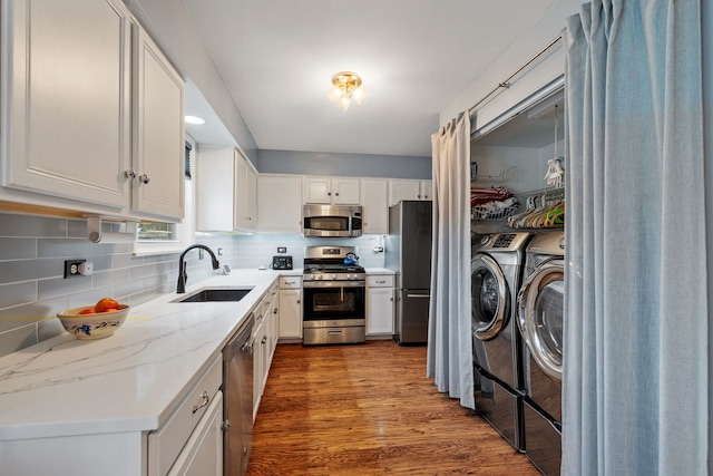 2706 Steamboat Cir, Plainfield, IL 60586 - kitchen with appliances with stainless steel finishes, washer and dryer, white cabinets, and wood finished floors