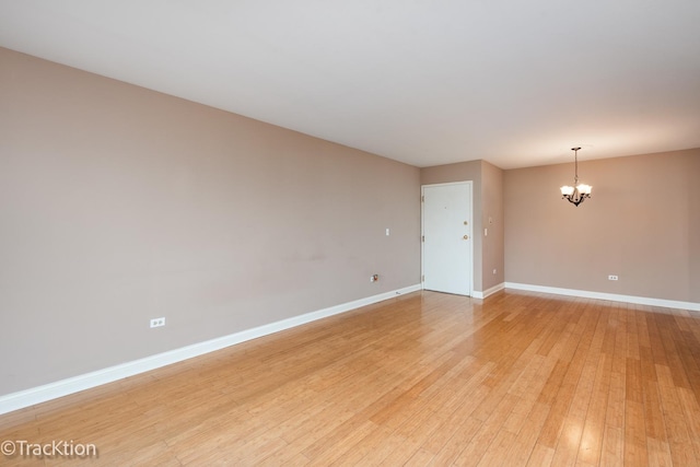1091 Rodenburg Rd Unit 303, Roselle, IL 60172 - empty room featuring a chandelier and light wood-style floors