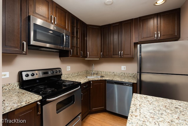 1091 Rodenburg Rd Unit 303, Roselle, IL 60172 - kitchen featuring stainless steel appliances, dark brown cabinetry, light wood-style flooring, light stone counters, and recessed lighting