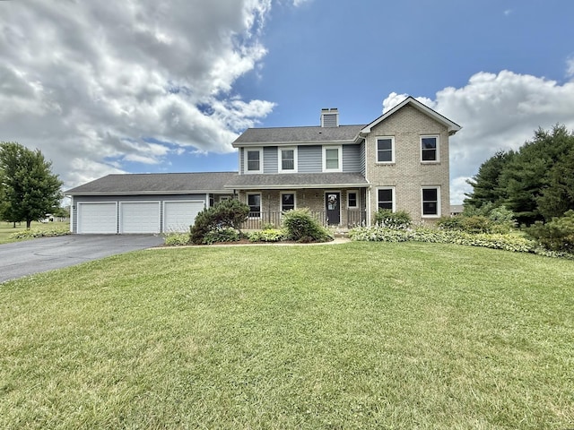 5448 S Branch Ct, Rochelle, IL 61068 - traditional home with asphalt driveway, a garage, a front yard, a chimney, and covered porch