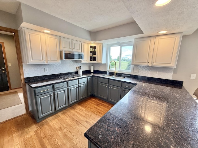 5448 S Branch Ct, Rochelle, IL 61068 - kitchen with a textured ceiling, appliances with stainless steel finishes, backsplash, light wood-style floors, and gray cabinets