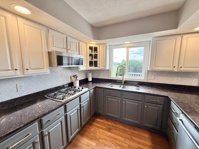 5448 S Branch Ct, Rochelle, IL 61068 - kitchen featuring stainless steel appliances, light wood finished floors, a textured ceiling, gray cabinets, and decorative backsplash