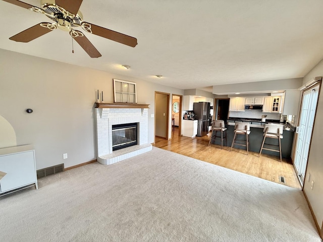 5448 S Branch Ct, Rochelle, IL 61068 - living area featuring light carpet, a ceiling fan, and a brick fireplace
