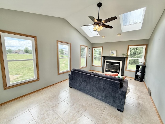5448 S Branch Ct, Rochelle, IL 61068 - living room featuring a skylight, vaulted ceiling, light tile patterned floors, a glass covered fireplace, and a ceiling fan