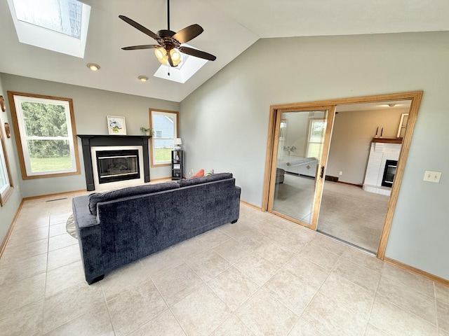 5448 S Branch Ct, Rochelle, IL 61068 - living area with a glass covered fireplace, a skylight, lofted ceiling, a ceiling fan, and light tile patterned floors